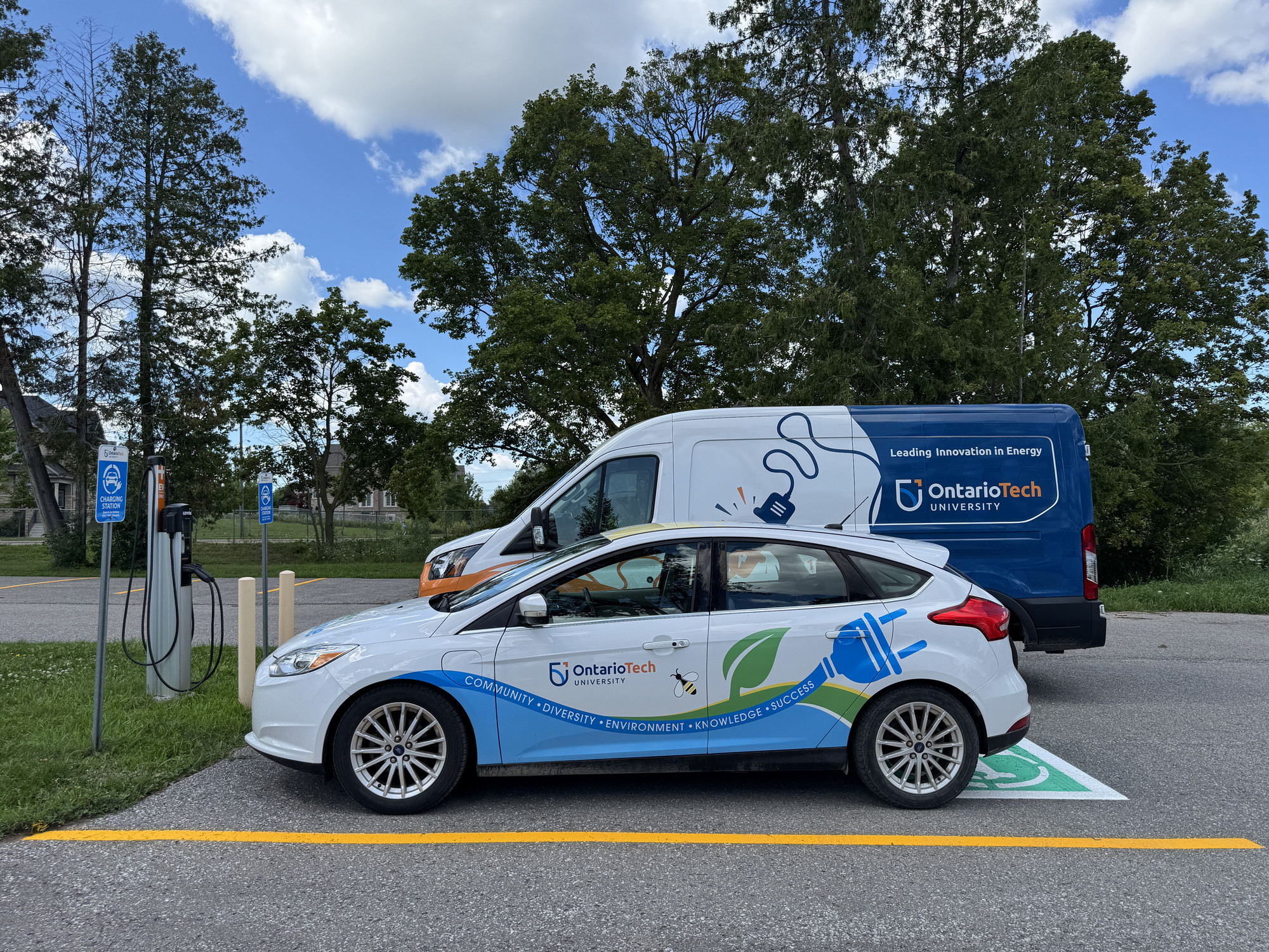 Two electric vehicles parked at the Office of Campus Infrastructure and Sustainability. 