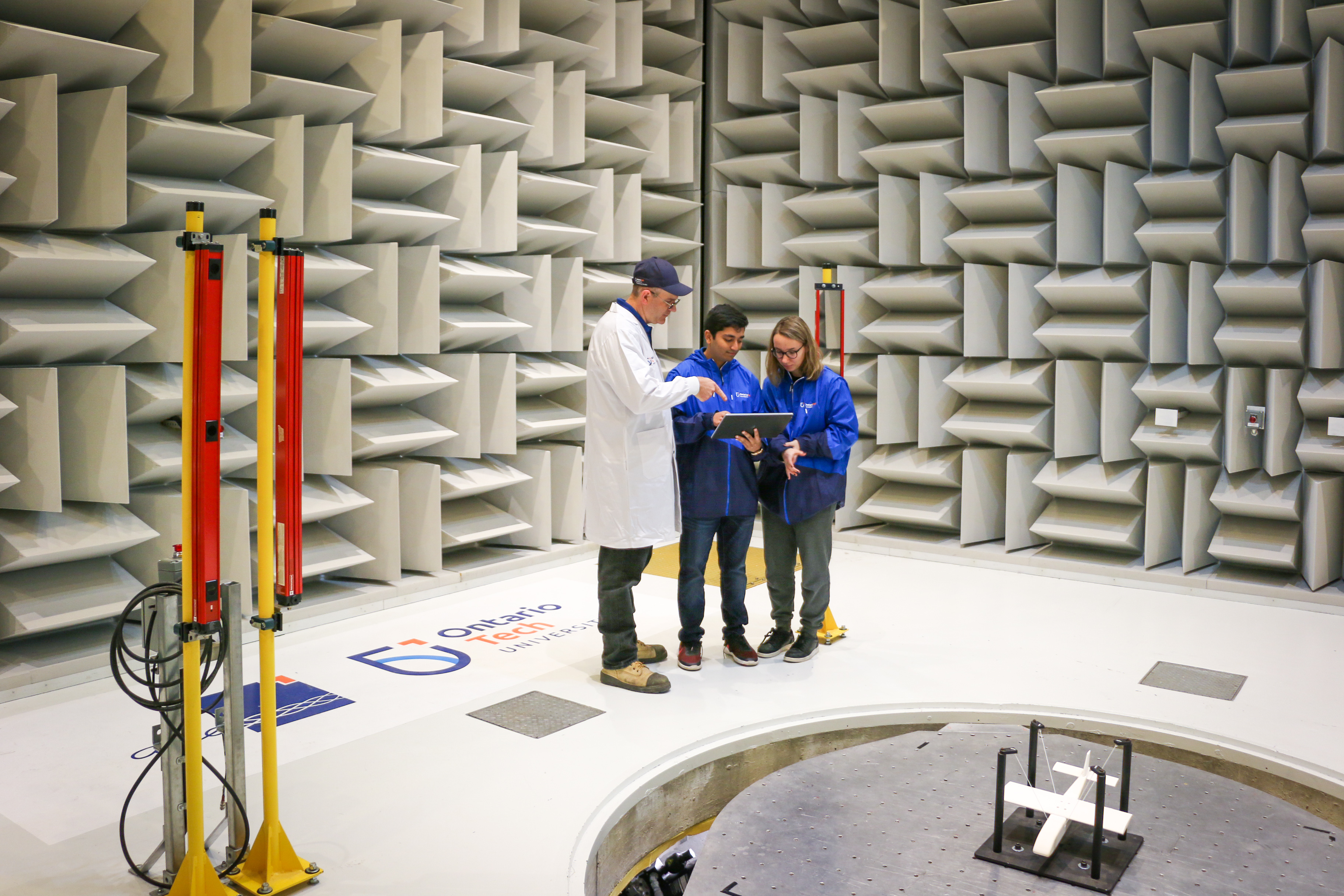 An ACE engineer with two ACE students in the Hemi-Anechoic chamber. 