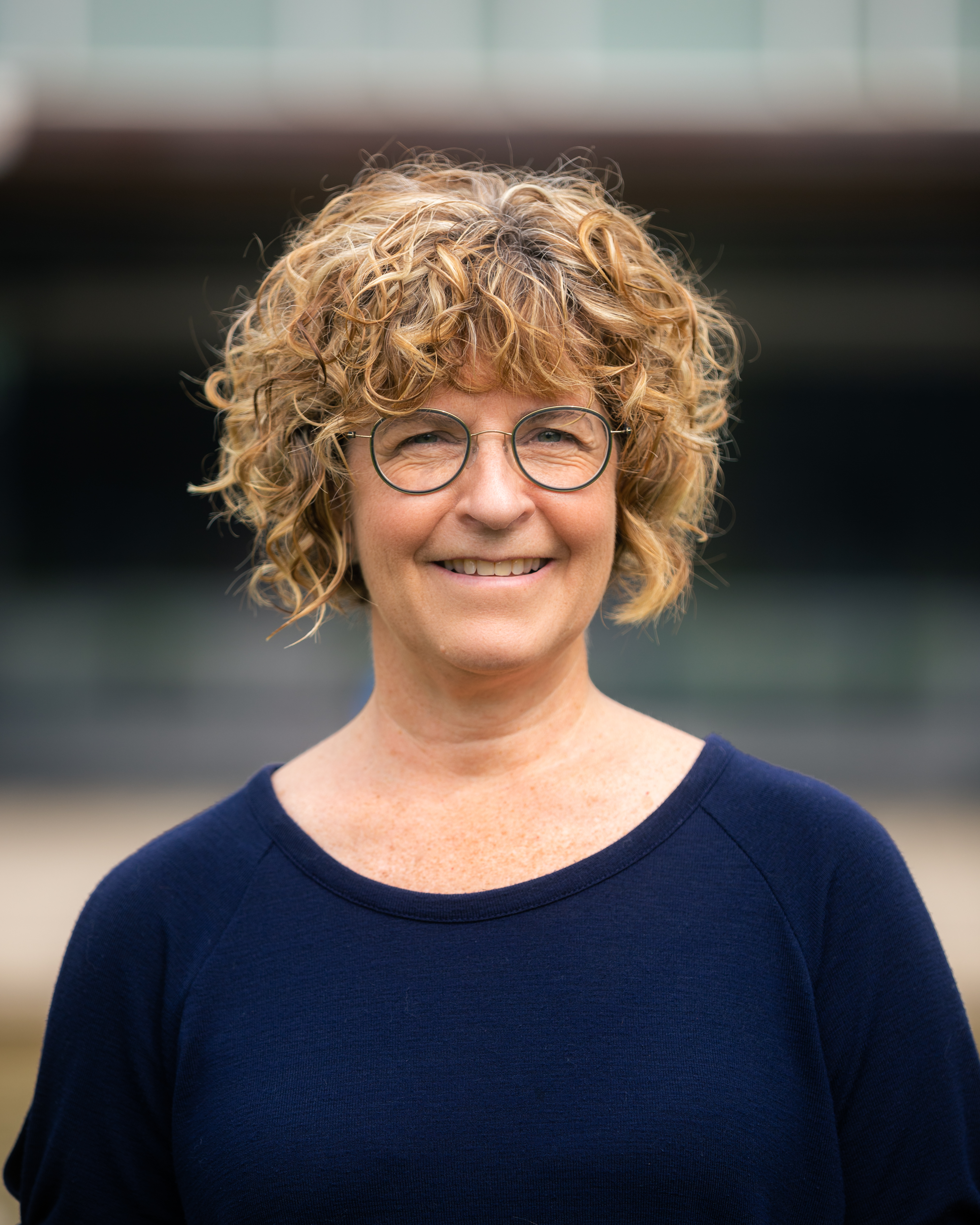 Susan Snelling wearing a navy blue top against a blurred background.