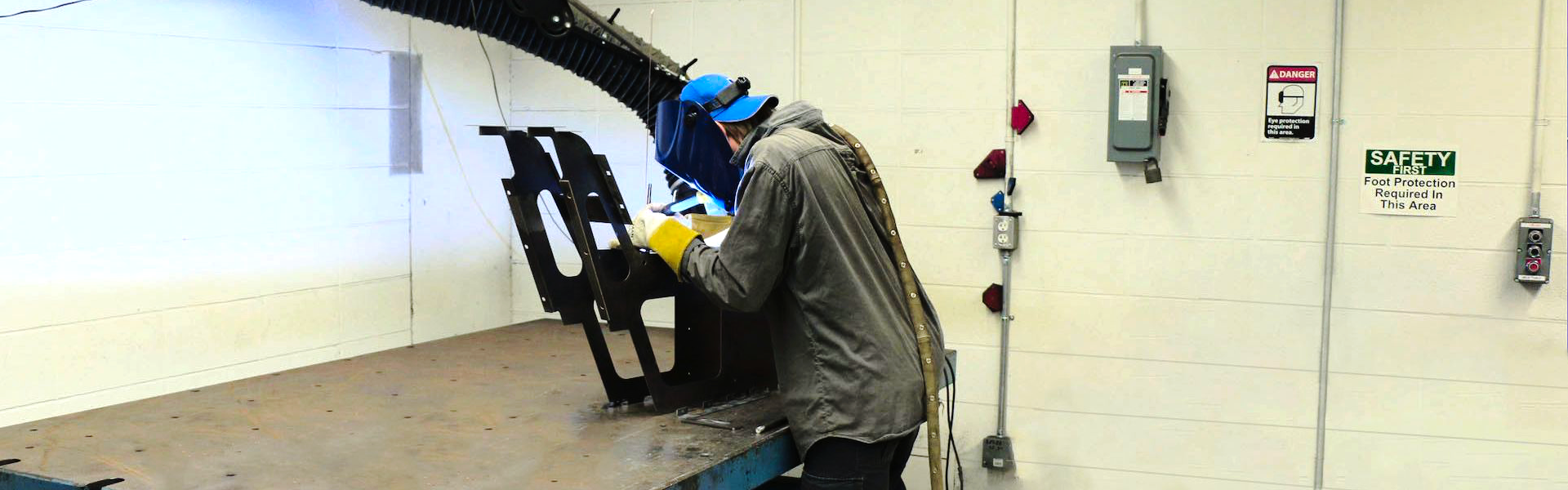 An ACE employee is using a piece of equipment in the machine shop.