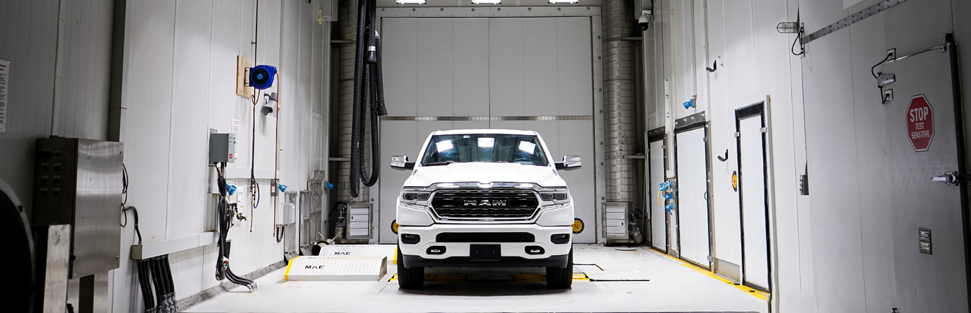 A white Dodge Ram is on the dyno under the solar array in the Large Climatic Chamber (LCC).