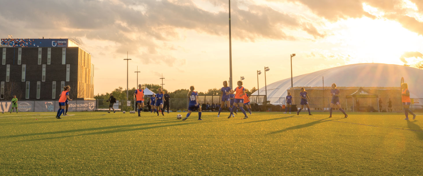 Womens Varsity Soccer team playing at sunset on Vaso's Field.