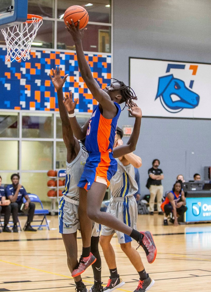 Ridgebacks Men's Varsity Basketball players score during game on campus.