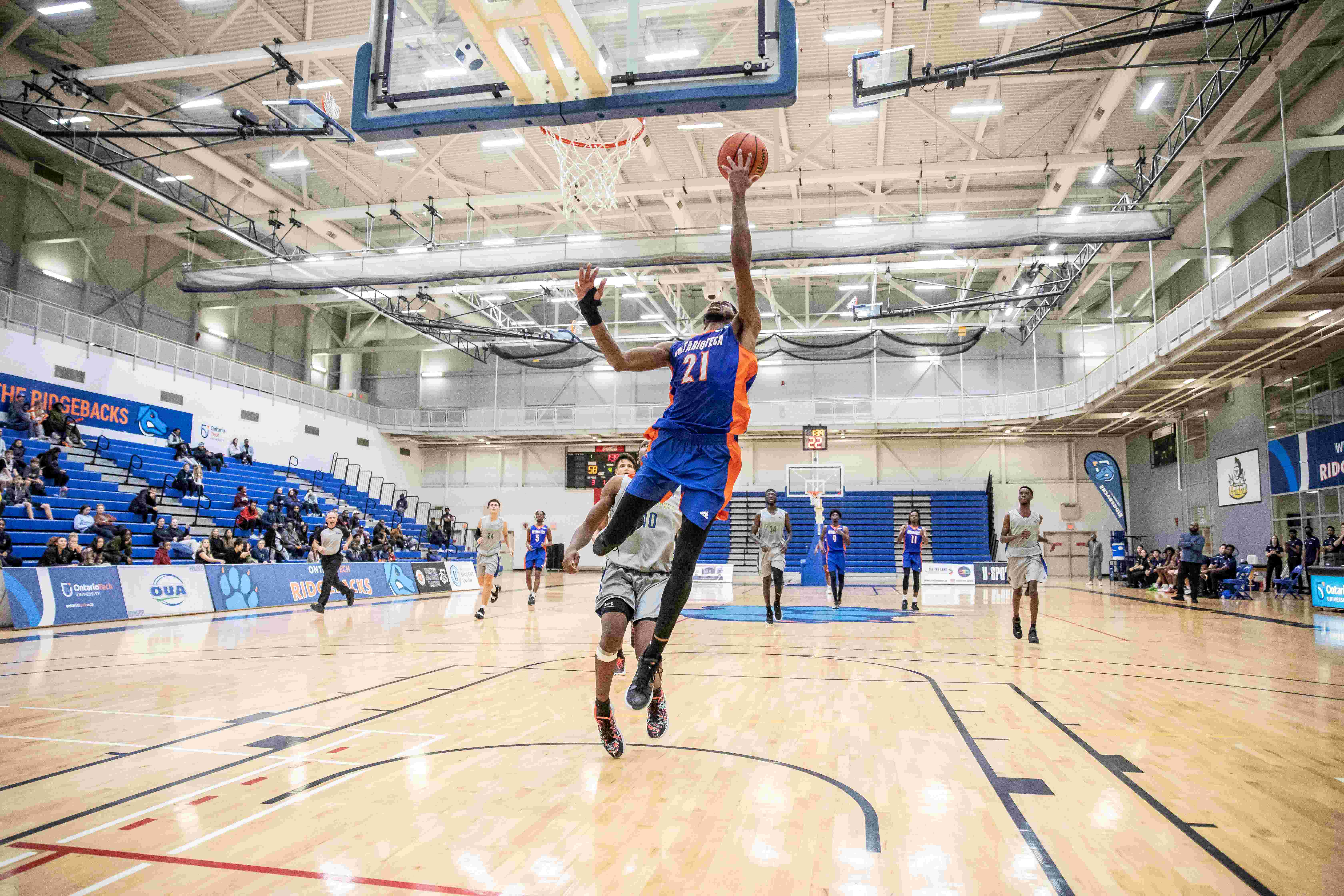 A member of the men's basketball team jumps while trying to score a basket.