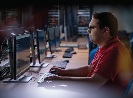 Student sits at a computer in a computer lab,