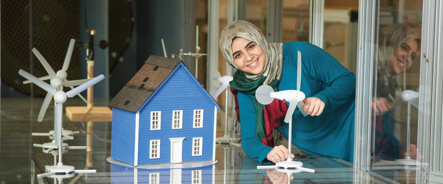 A student smiles in a lab in the Faculty of Engineering and Applied Science.