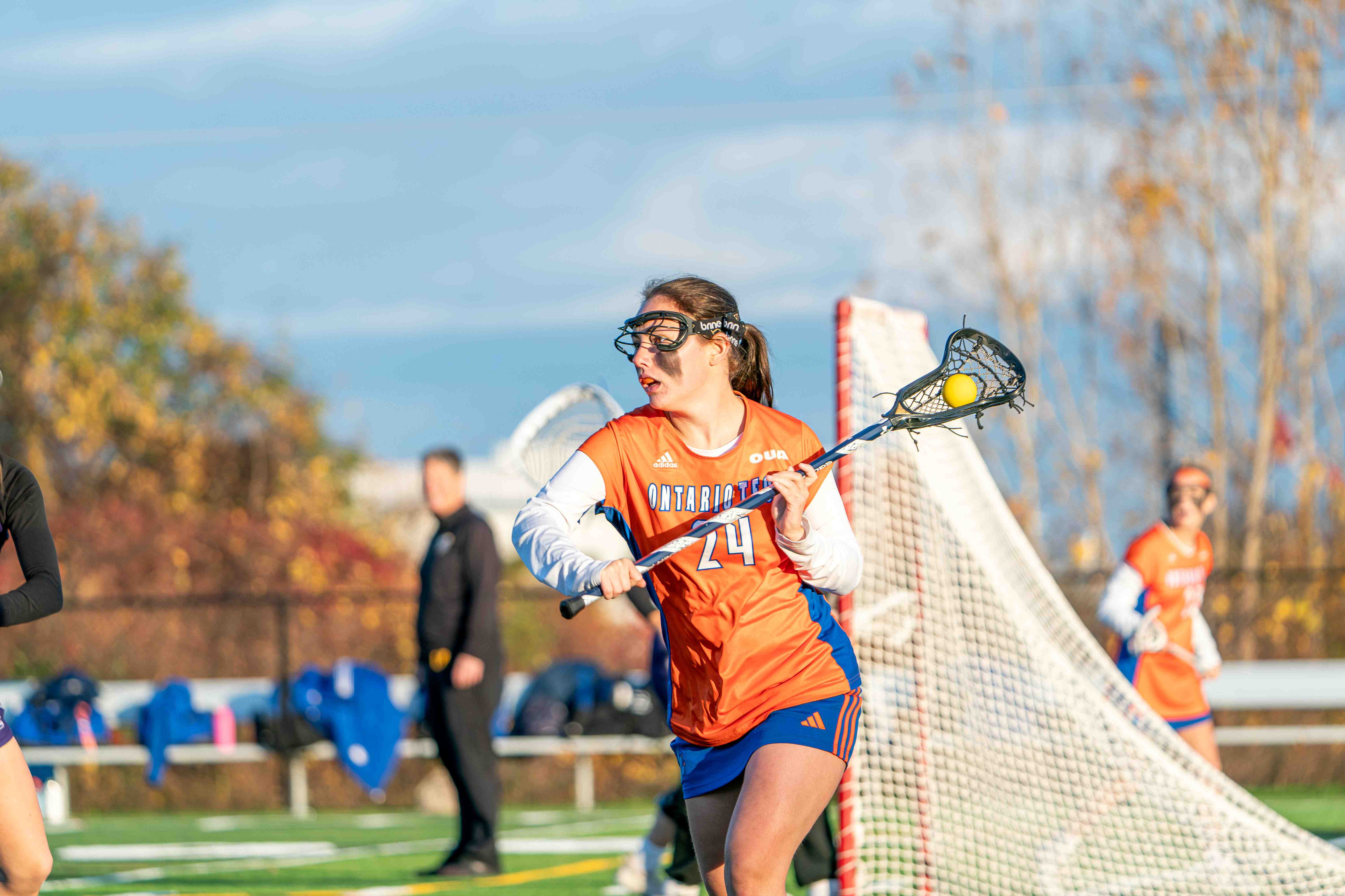 A member of the Ridgeback Women's lacrosse team playing on the field.