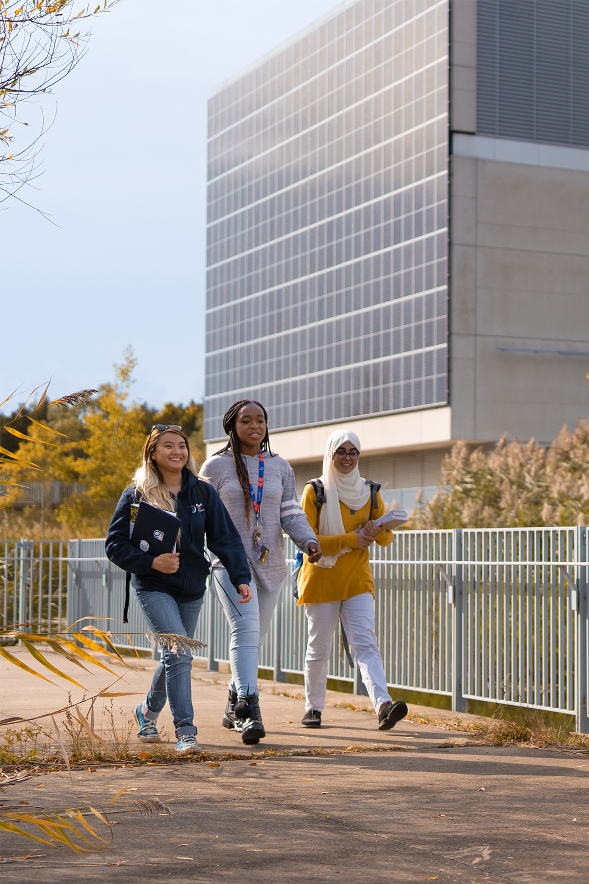 Students standing outside with the solar wall on ACE in the background.