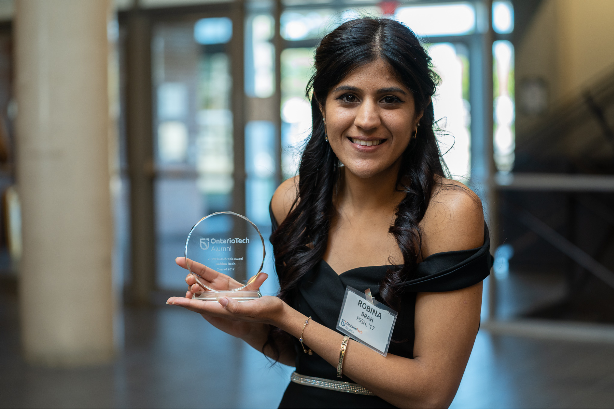 picture of alumni association council member robina holding up award.