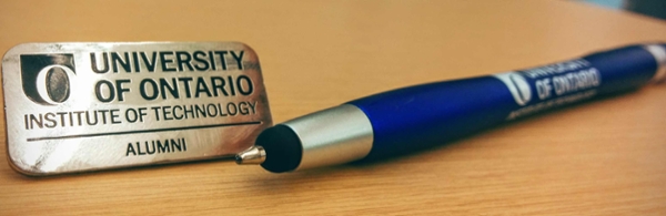 A pen and sign that says: University of Ontario Institute of Technology Alumni