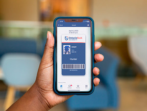 Photo of someone holding a phone with the digital Ucard displayed on the screen