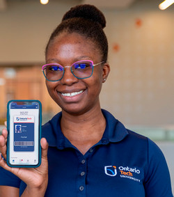 Staff member holding a phone with their digital Ucard displayed on the screen