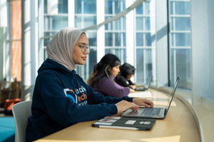 Students study on laptops in the library.