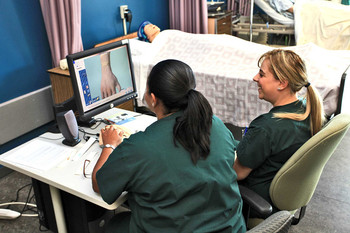 Health students with computer and mannequin