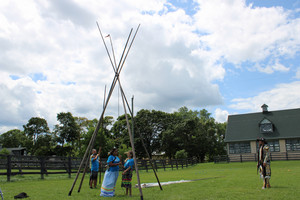 Turtle Island campers helping erect a tepee.