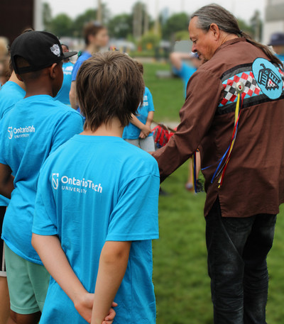 A photo of campers interacting with an Indigenous Elder.