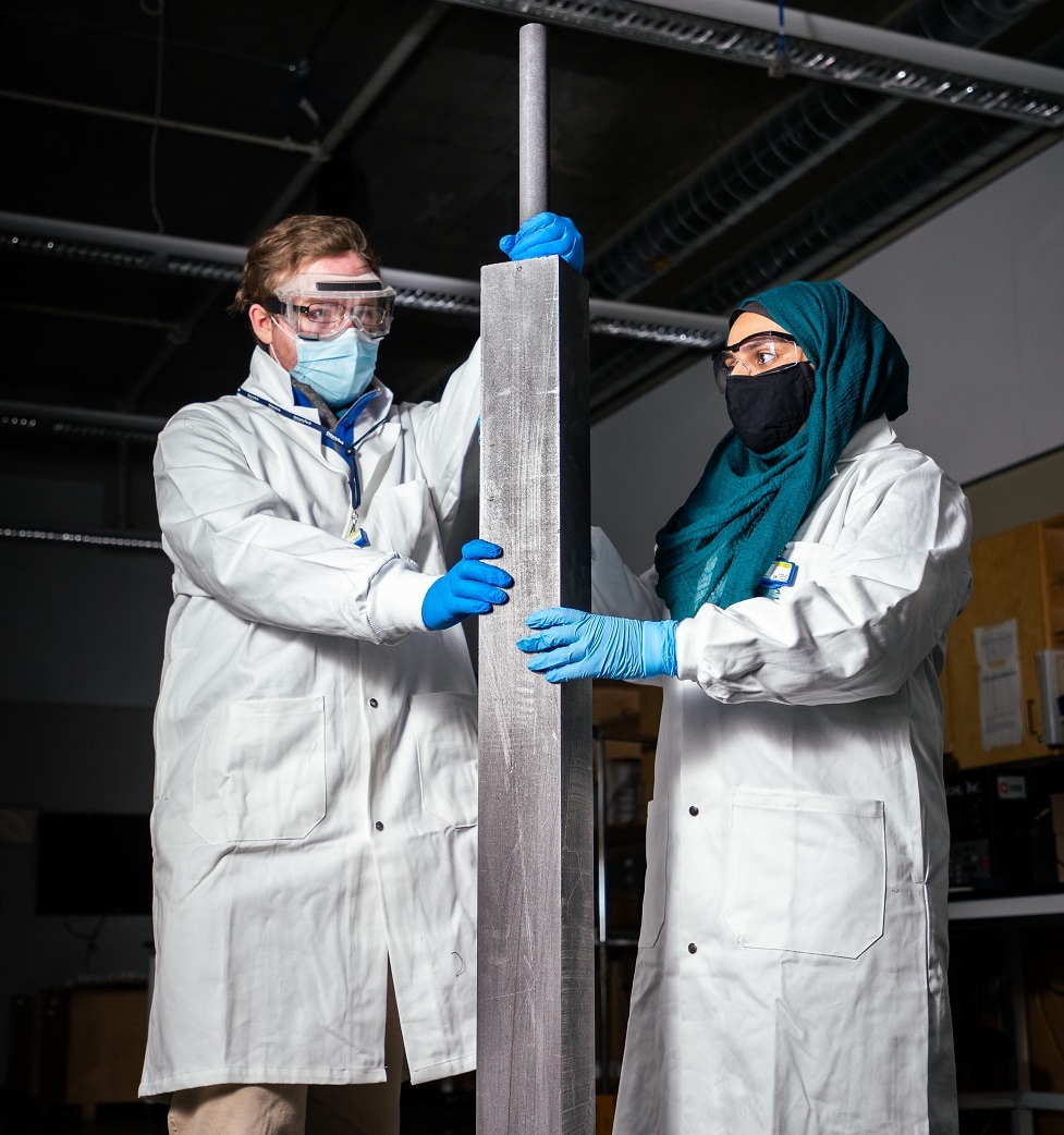 Researchers removing a graphite moderator rod