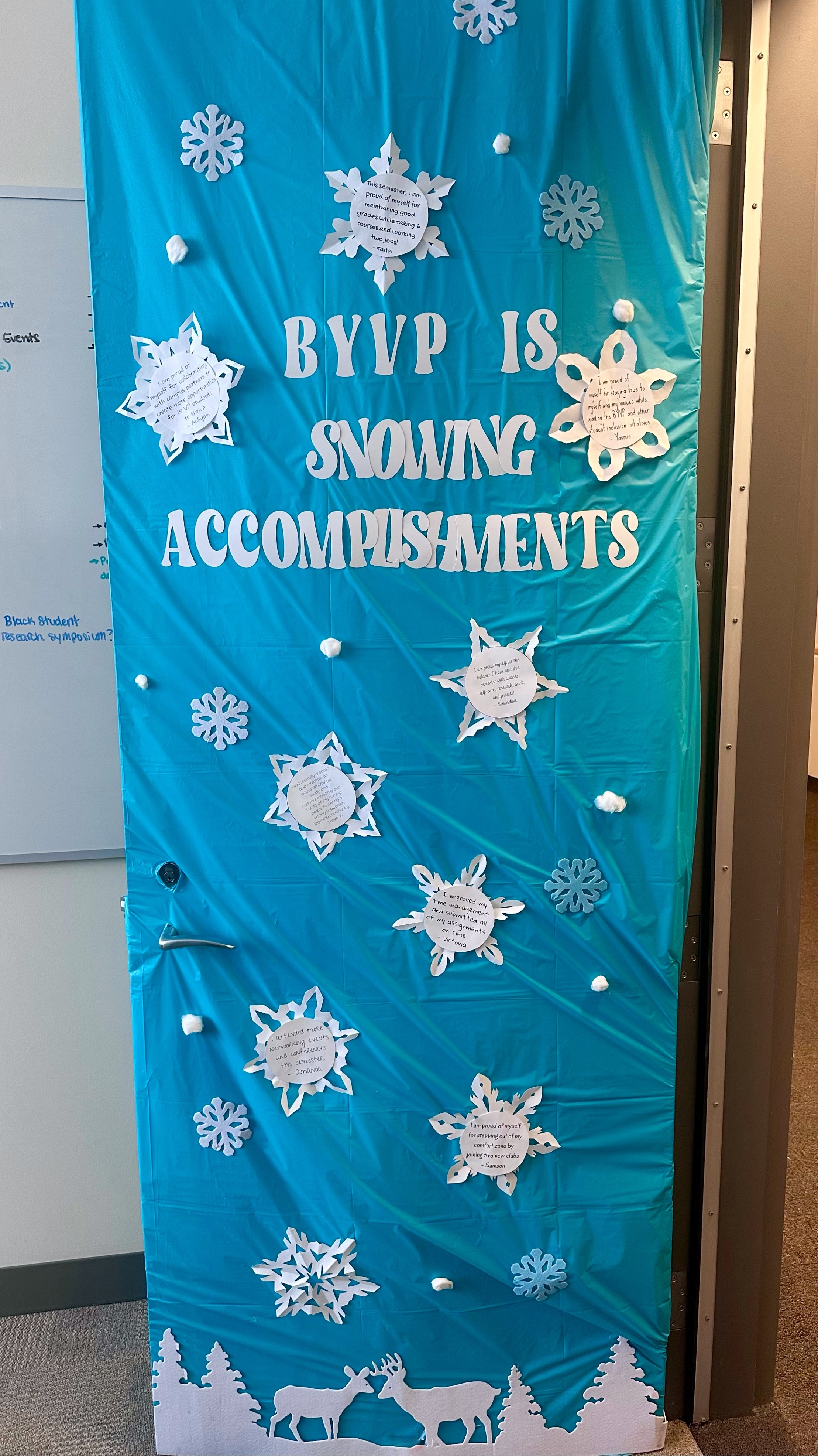 A decorative door display featuring the text "BYVP IS SNOWING ACCOMPLISHMENTS" surrounded by snowflakes and holiday-themed elements.