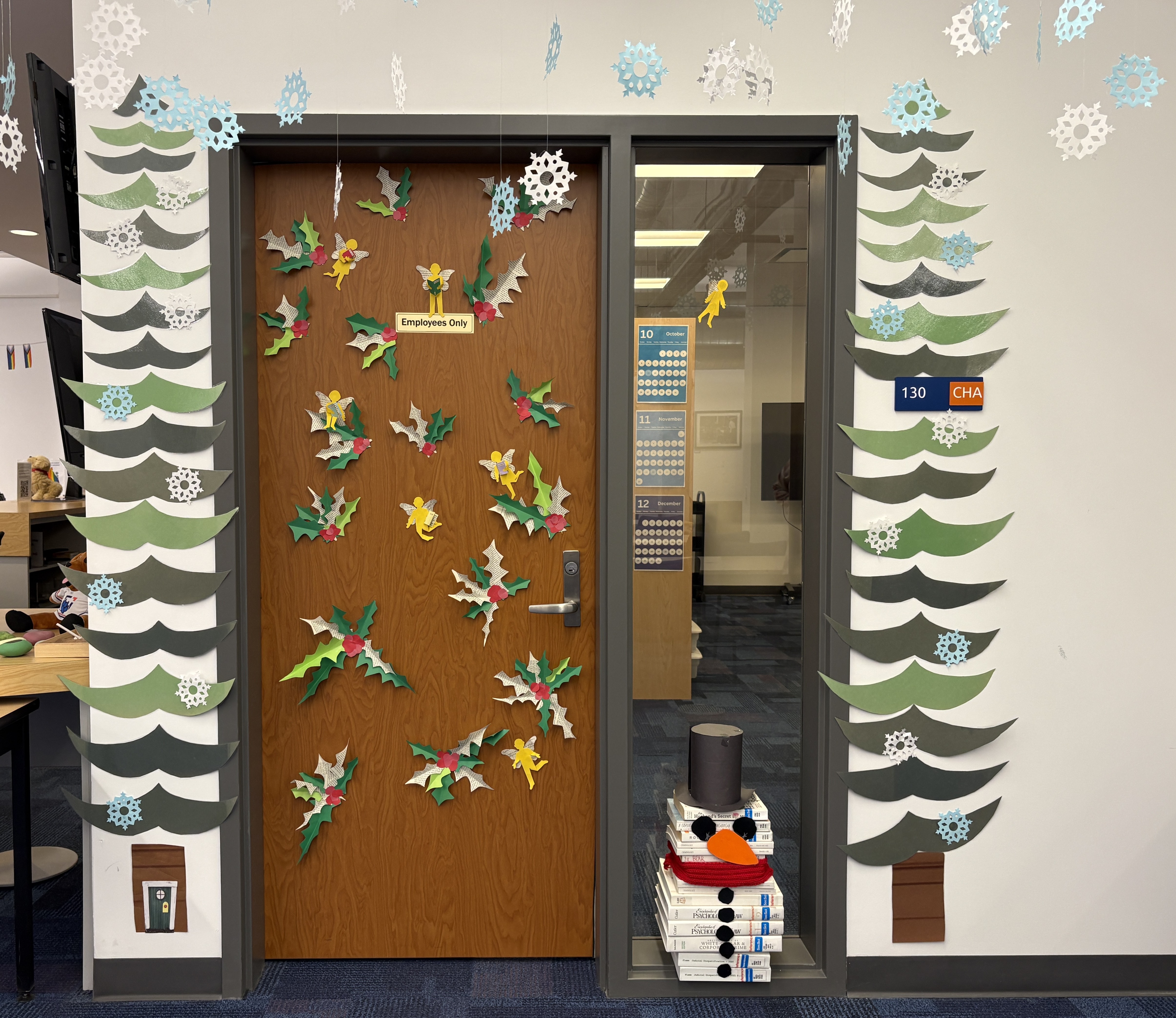 Holiday door decorated with holly and fairies.