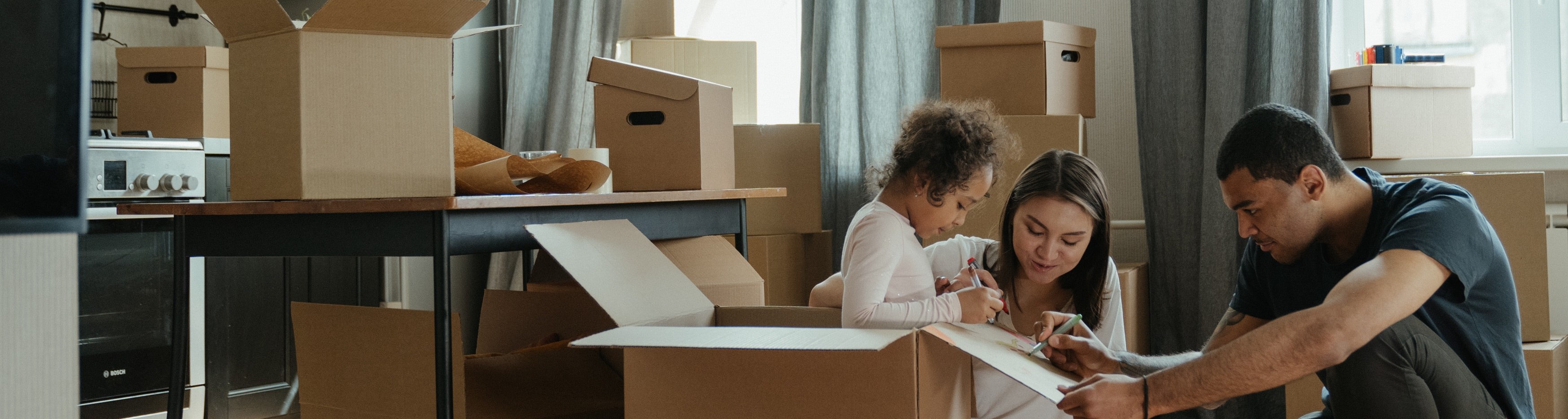 Image of a family packing boxes to move.