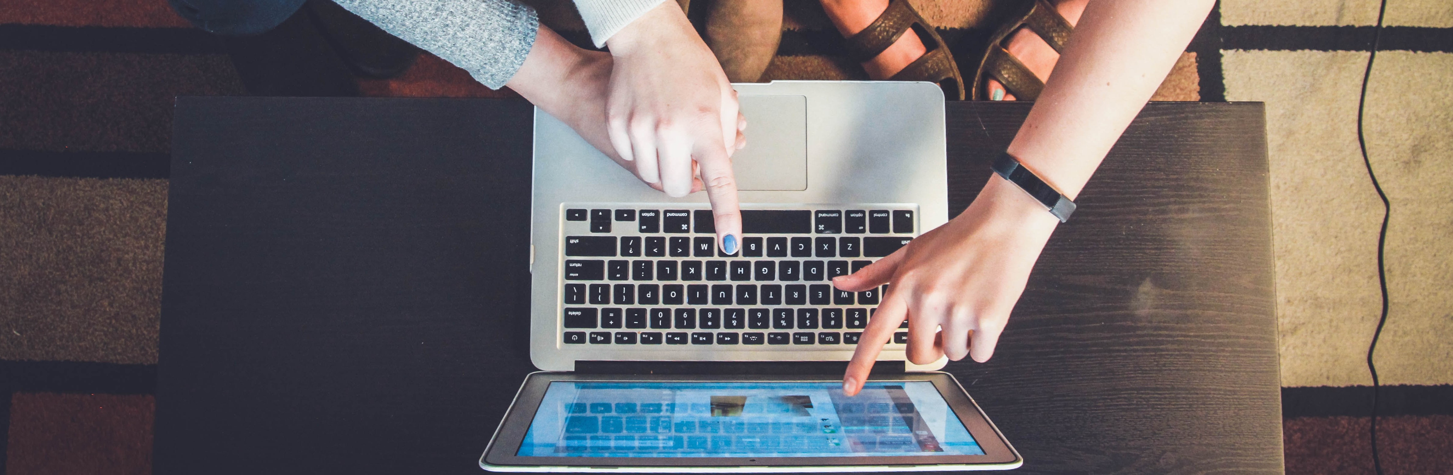 Three people looking at a laptop. Photo by John Schnobrich on Unsplash