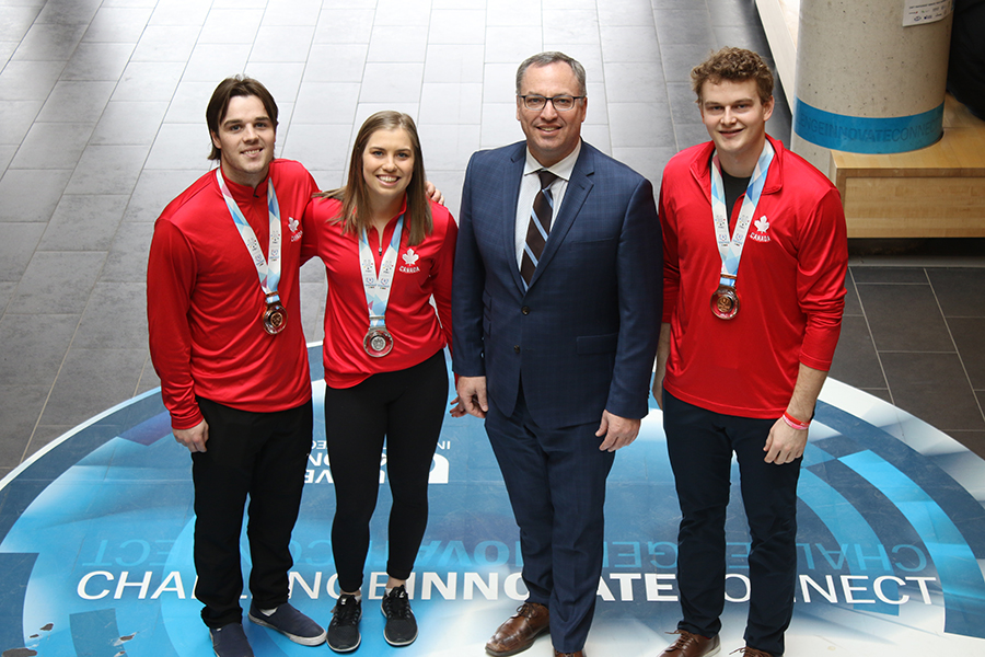 鶹ý Ridgebacks hockey stars Alex Yuill (left), Kassidy Nauboris (centre-left) and Jack Patterson (right) with President Steven Murphy.