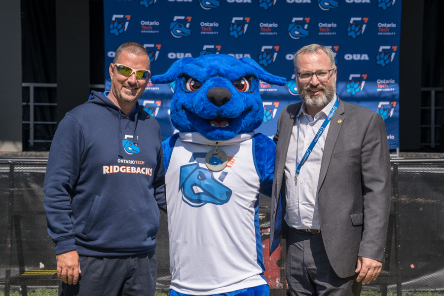 From left: Scott Barker, Director, Athletics, with Hunter the Ridgeback and President Steven Murphy.