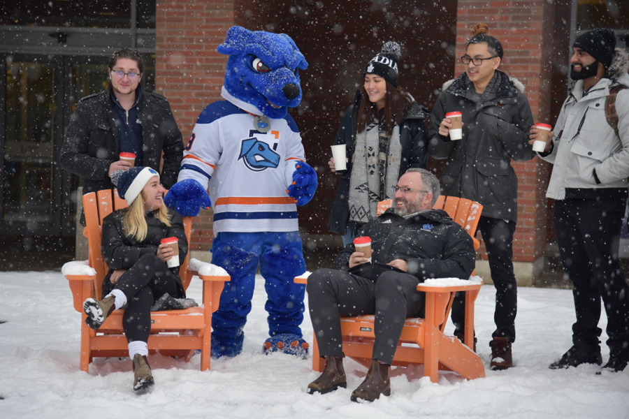 President Steven Murphy with 鶹ý University students and Hunter the Ridgeback in front of the North Oshawa Campus Library in the winter.