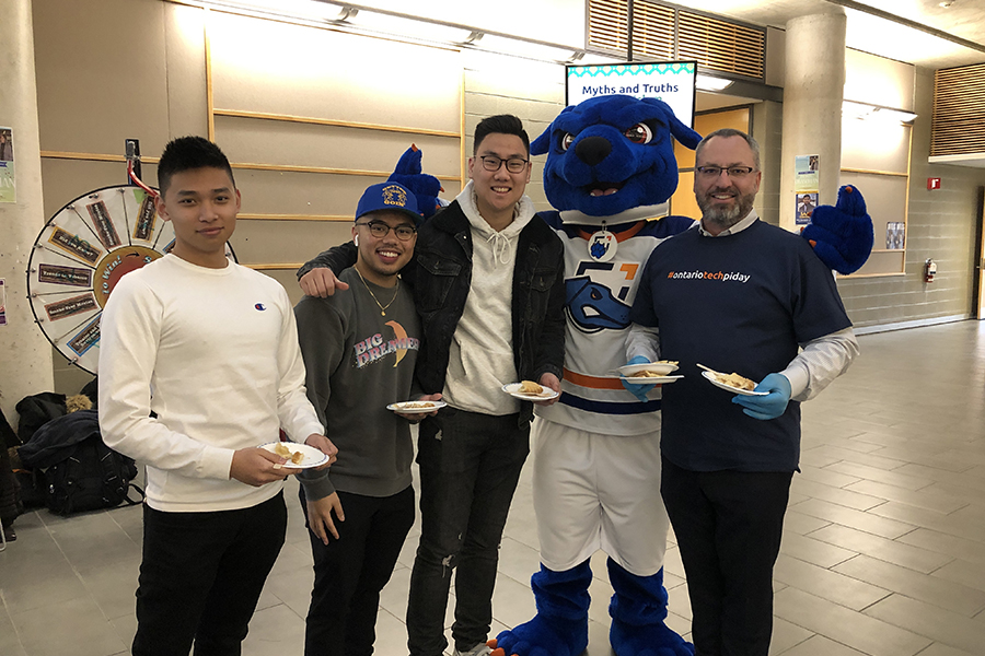 President Steven Murphy with 鶹ý University students and Hunter the Ridgeback at the university's Pi Day event.