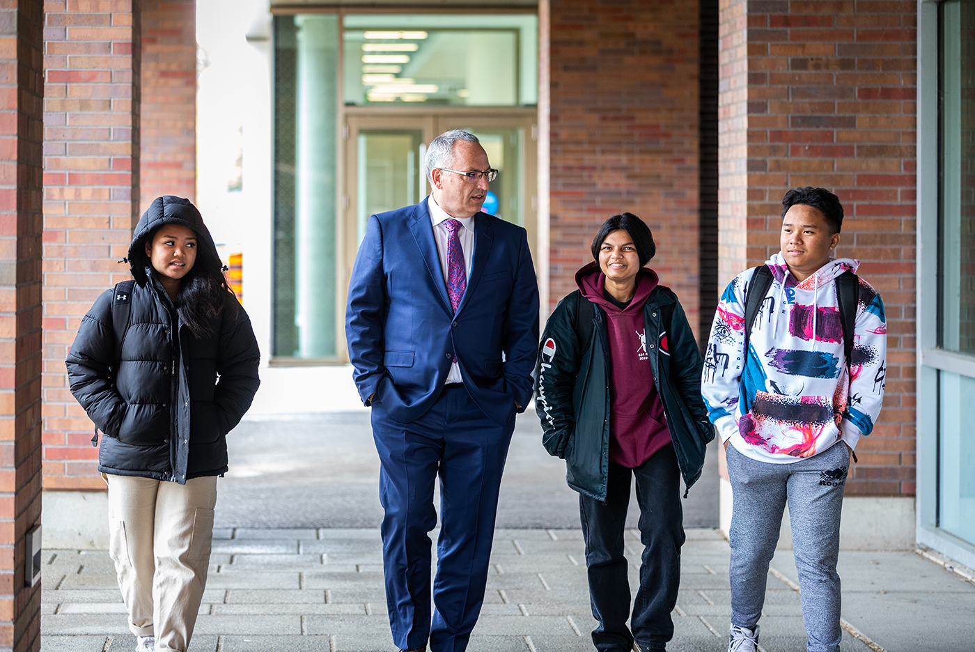 President Steven Murphy walking with students at 鶹ý University's north Oshawa campus location.
