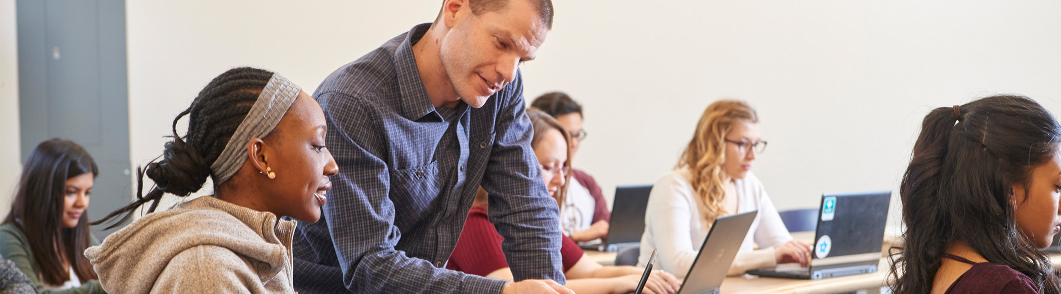 A student being assisted by an instructor in the classroom