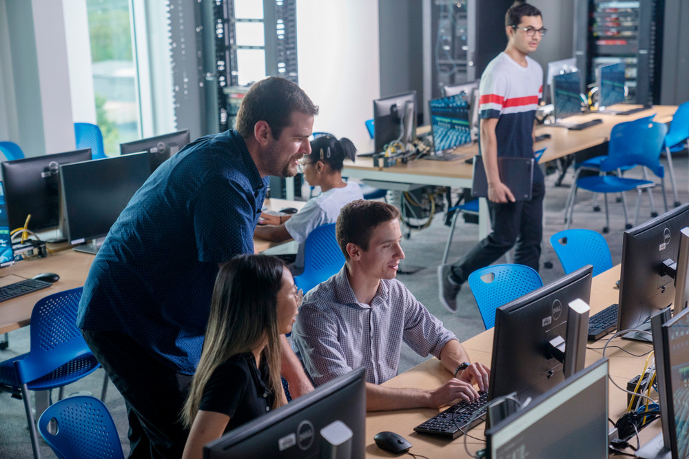 Students with professor in computer lab. 