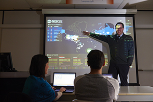 professor with map and students watching map on screen