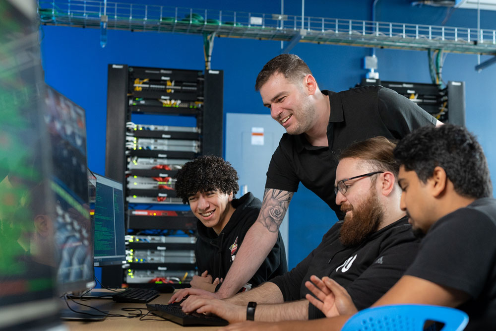 An instructor looks over a group of students working around a table