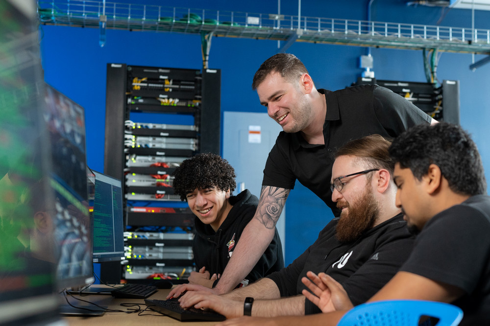 Students and professor working on computers. 