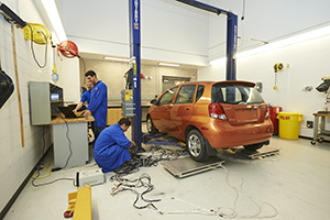 Two Automotive Engineering working on a car at the university