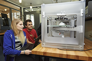 Professor and student examining lab equipment.