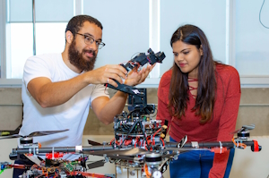 Two graduate students working on a mechatronics project.