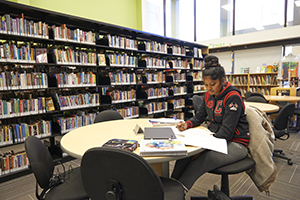 student at a table studying in library