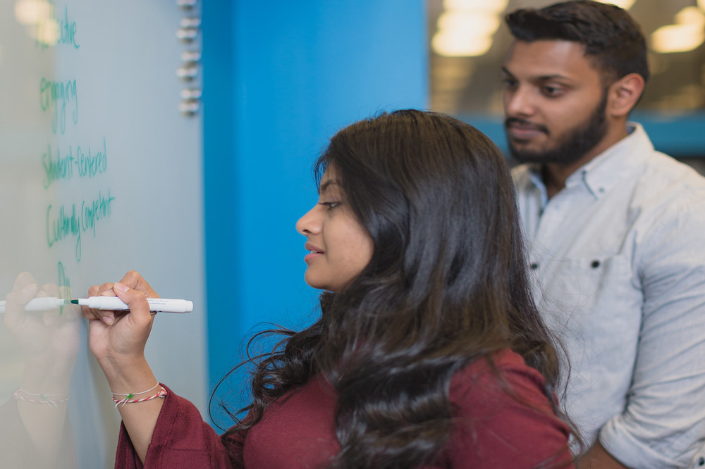 a student writes on a whiteboard