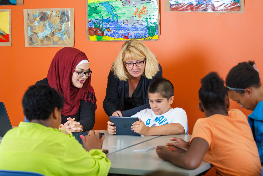 two teachers and students at table