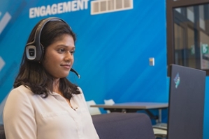 Female student with headset looking at a computer