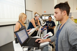 Group of students doing research on someone exercising on a bike