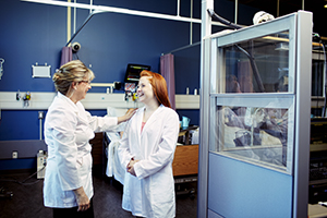 A female instructor talks with a female student in a lab