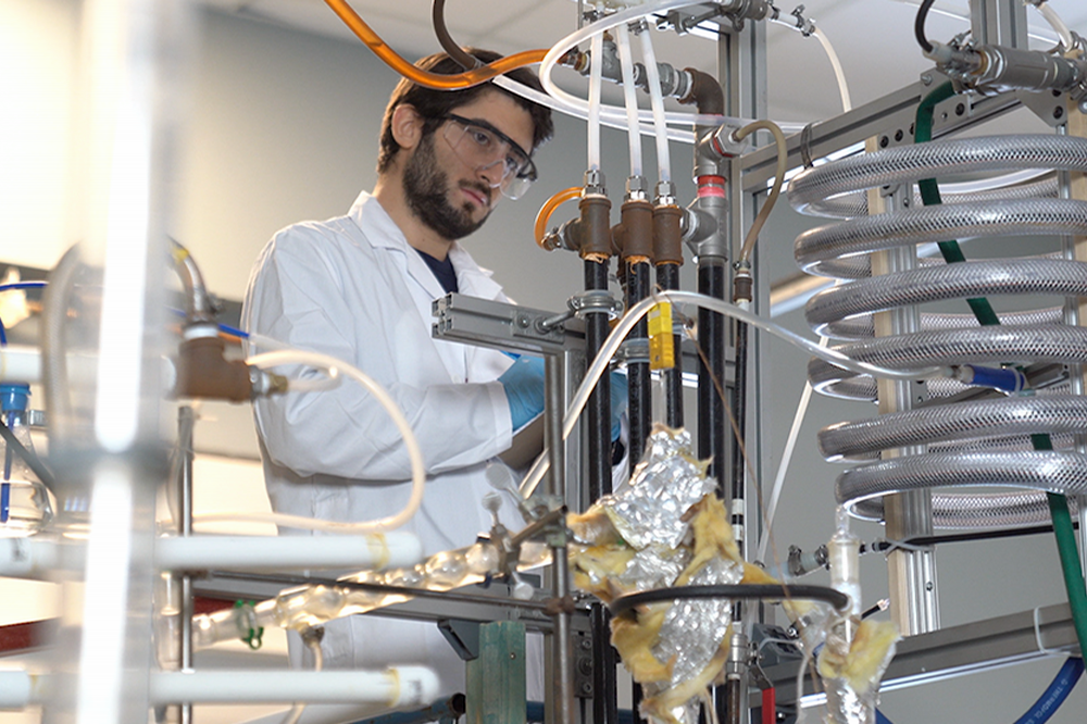 student in front of chemical lab equipment