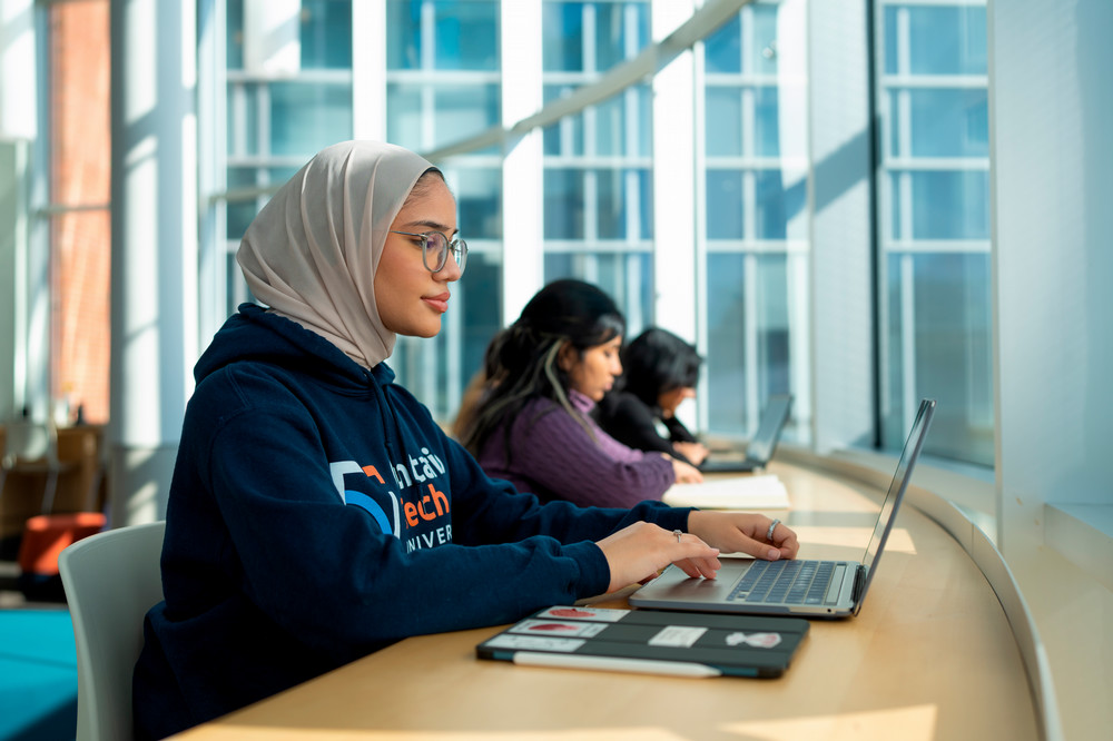 Student at computer in library. 