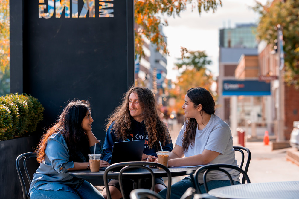 Students sitting outside downtown Oshawa campus.