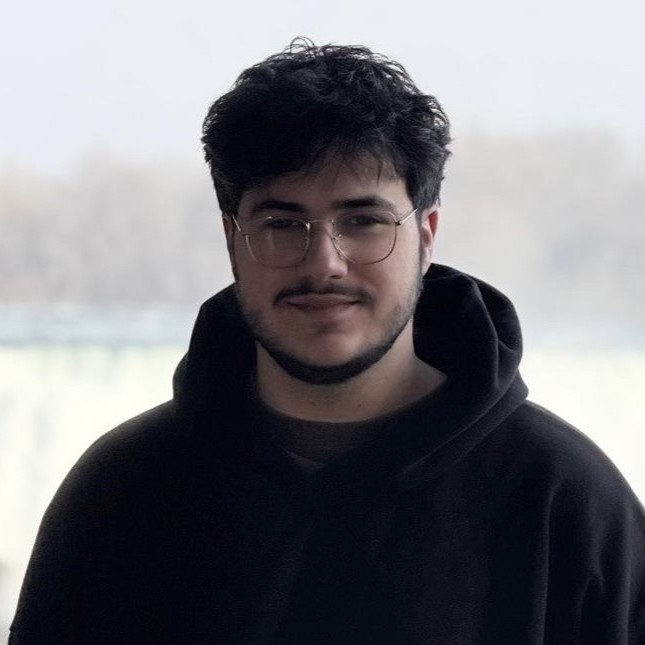 A photo of Rami El-Emam pointing to a board. 