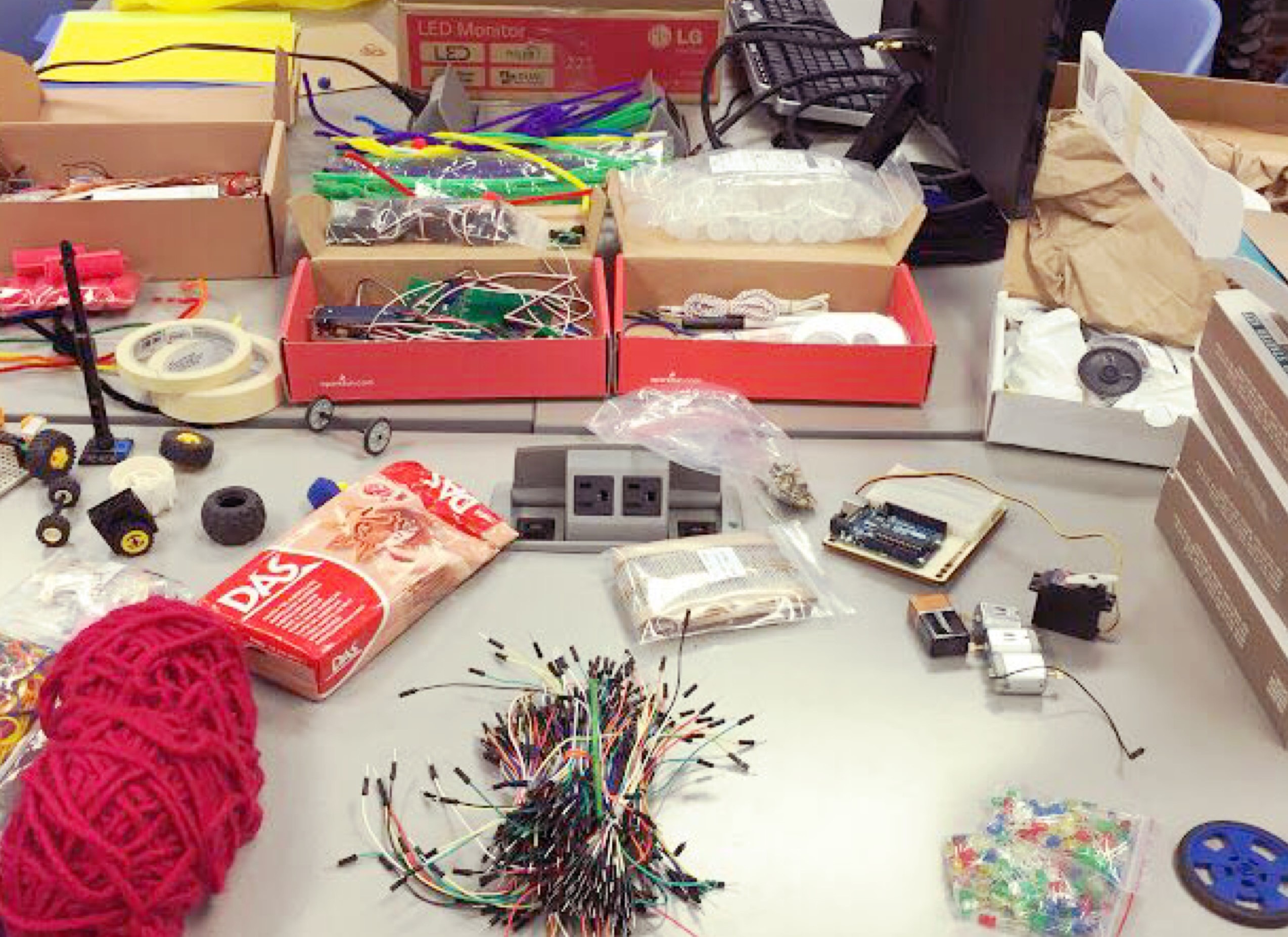 A work table filled with various electronic and arts parts such as wires, in the STEAM lab