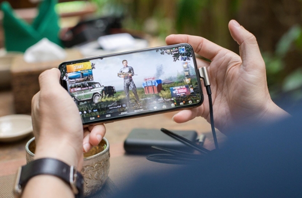 Hands holding the phone with PubG Mobile game. 